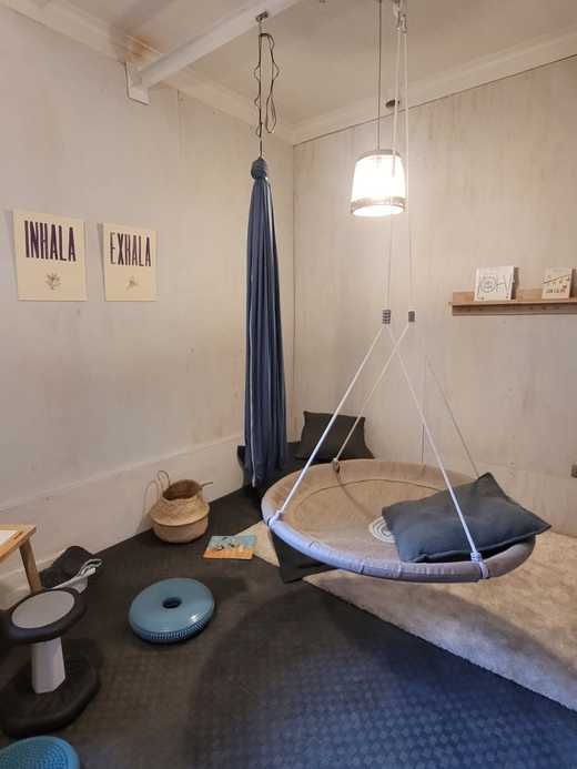 Ejemplo de espacio en calma del Museo Taller. En la imagen se distinguen elementos como un vestibulador tipo hamaca y otro tipo plataforma blanda, un bosu, cancelador de ruido y cojines cómodos.