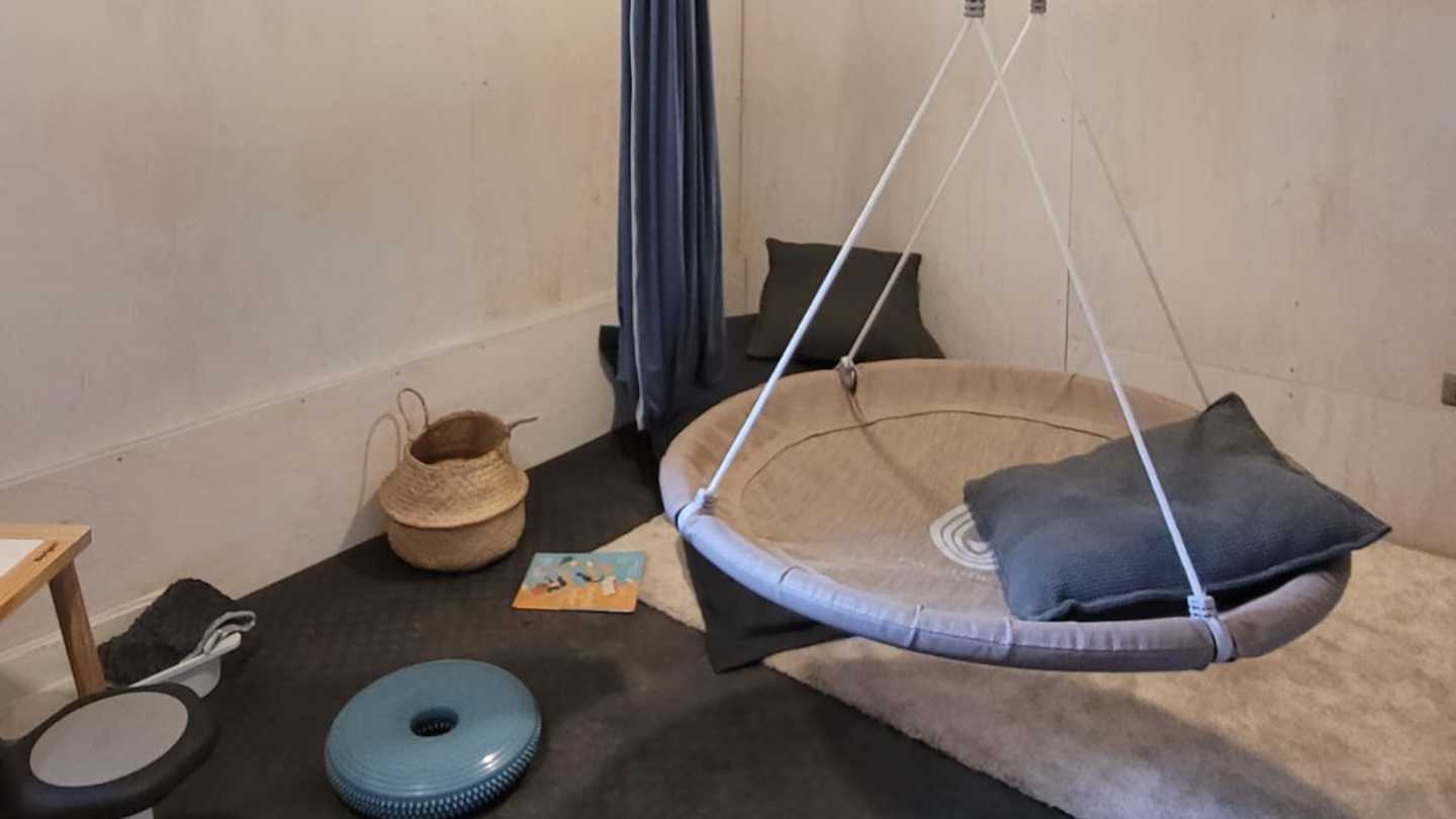 Ejemplo de espacio en calma del Museo Taller. En la imagen se distinguen elementos como un vestibulador tipo hamaca y otro tipo plataforma blanda, un bosu, cancelador de ruido y cojines cómodos.