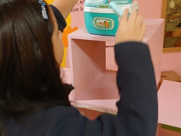 Laura y María Isabel realizan el montaje de su vitrina de juguetes